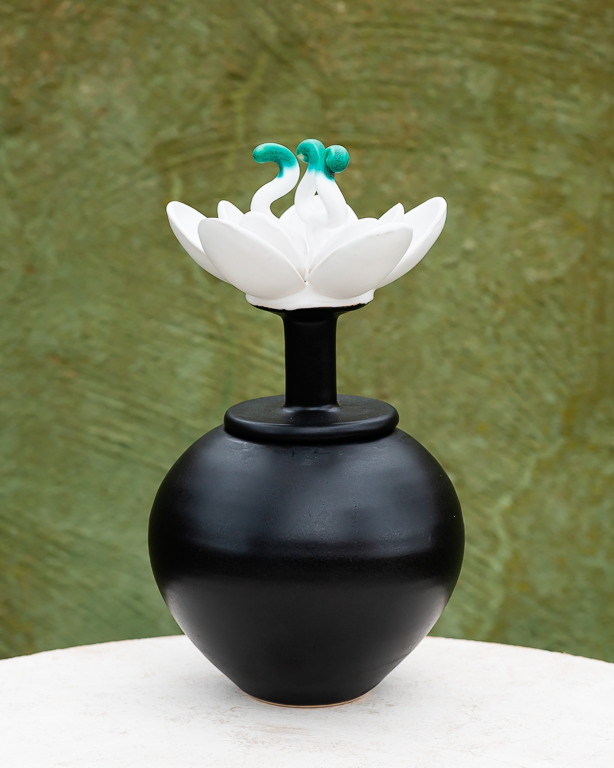 Svart burk - vas med vit blooma, keramik av Elna-Karin Helgesson.